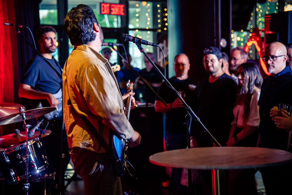 Ariel Posen and his band on stage at the Beyond the Burst Guitar Showcase, the crowd packed in front