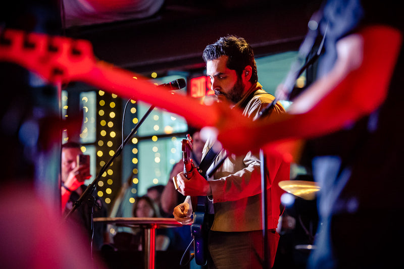Ariel Posen singing with his band at the Beyond the Burst Guitar Showcase
