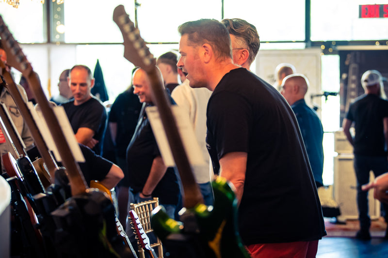 Guests among the guitar racks at the Beyond the Burst Guitar Showcase