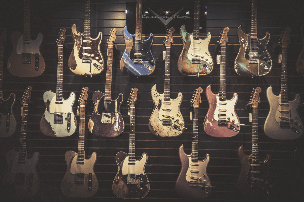 A wall of Fender Custom Shop electrics at Lauzon Music, relic'd Stratocasters and Telecasters hanging in rows under the Custom Shop sign